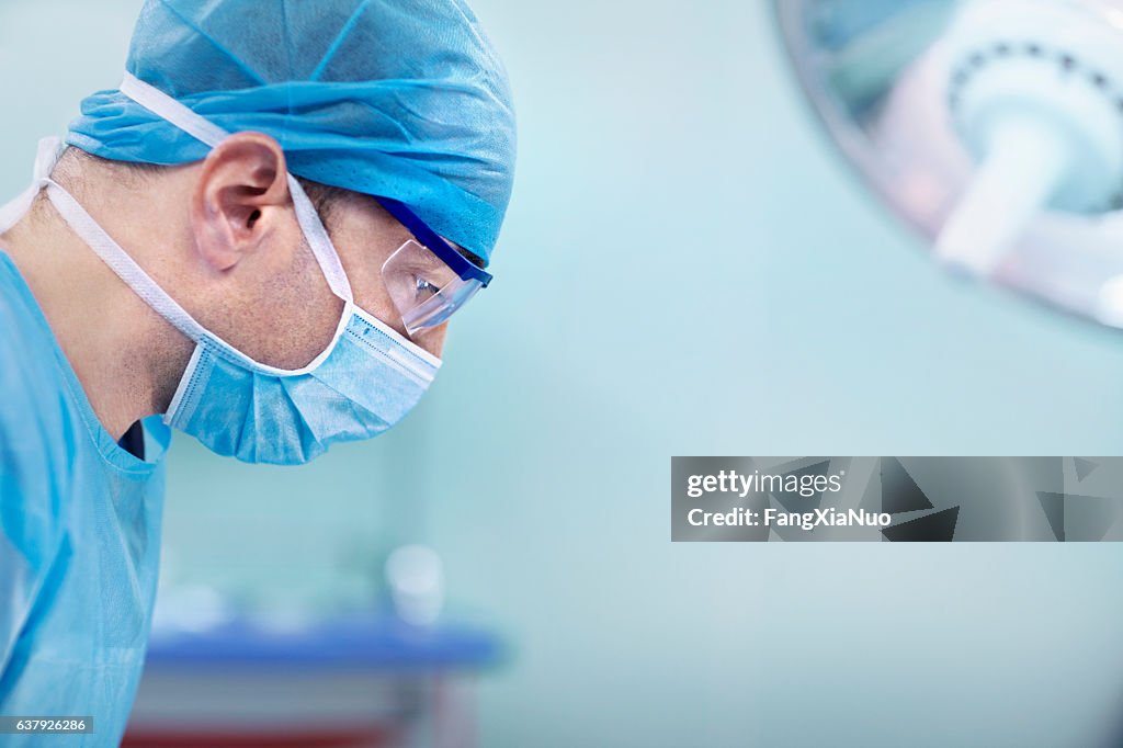 Doctor looking down at patient in hospital operating room