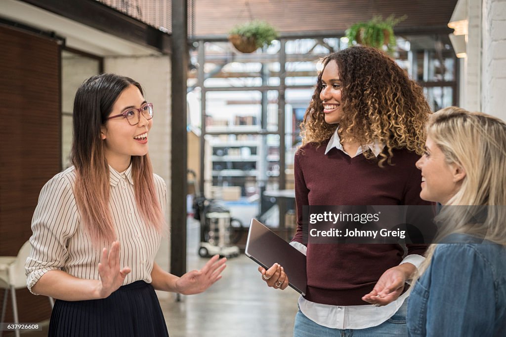 Three young women having conversation and laughing