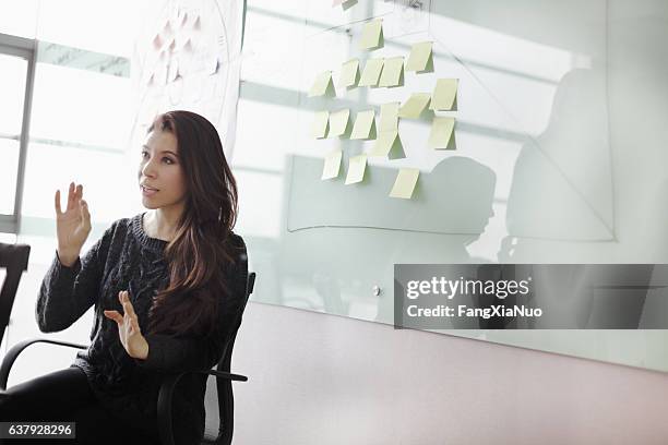 woman discussing ideas and strategy in studio office - people associated with politics & government stock pictures, royalty-free photos & images