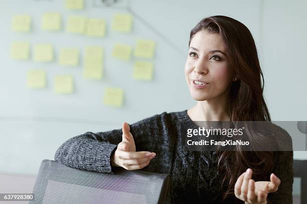 donna che discute idee e strategia in studio - esprimere a gesti foto e immagini stock