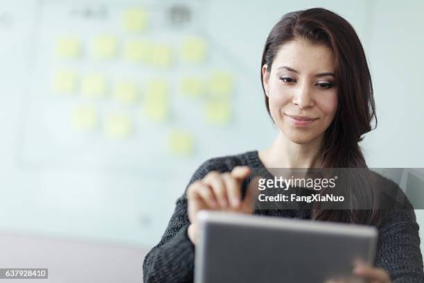 woman working on tablet computer in studio office - content strategy stockfoto's en -beelden