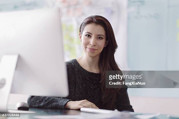 portrait of woman next to computer in studio office - agency creative stockfoto's en -beelden