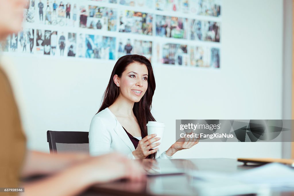 Woman talking to colleagues in design studio office meeting