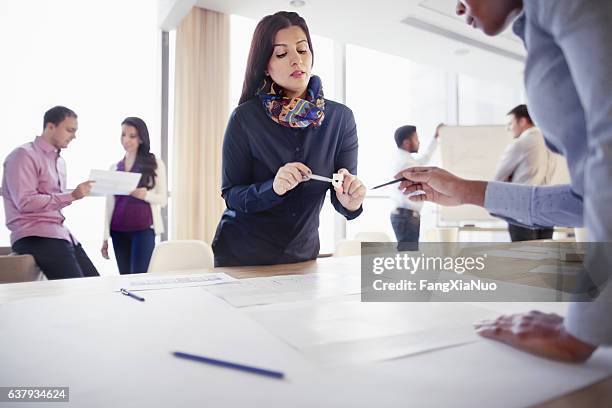 woman discussing part design with colleague in innovation studio - copyright stock pictures, royalty-free photos & images