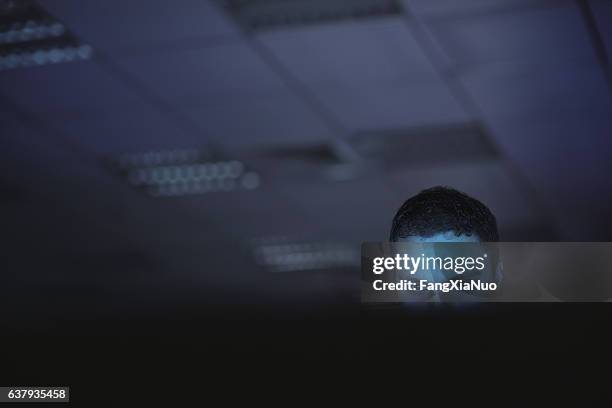 computer hacker working on laptop late at night in office - man robot stockfoto's en -beelden