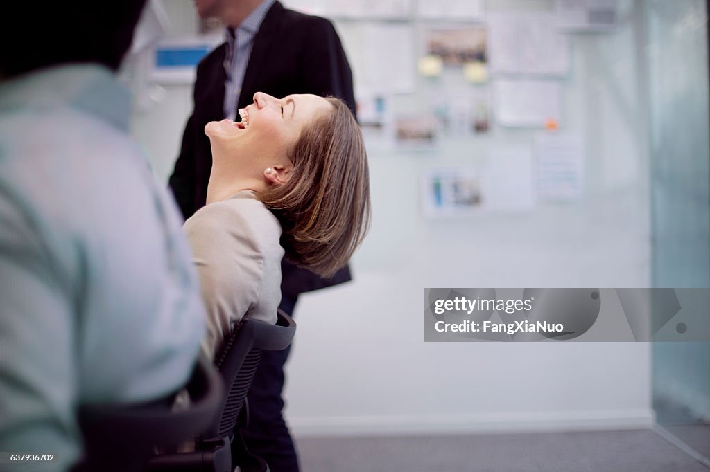 Businesswoman laughing reaction in office team meeting