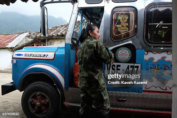 Female member of FARC's Sixth Front talks to the driver of a local bus by a roadside cafe outside a demobilization camp in the final days before...