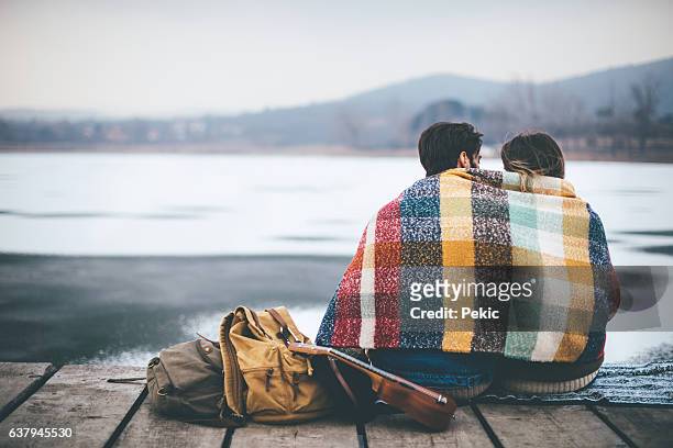 romantic young couple hugging by the lake in winter - emotion meer stockfoto's en -beelden