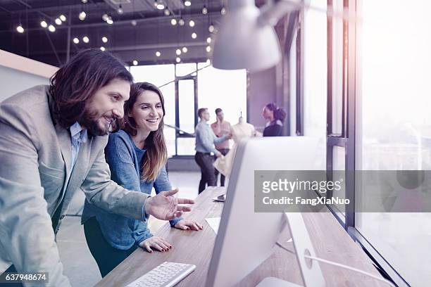 pair of fashion designers discussing ideas in design studio environment - cool office stockfoto's en -beelden