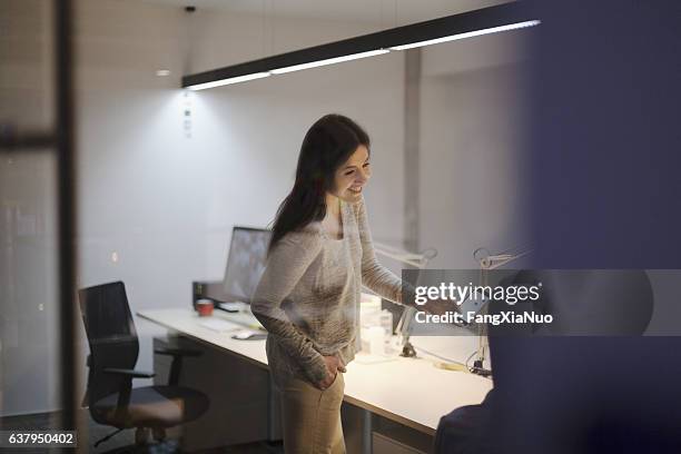 frau teilt idee auf smartphone mit mitarbeiter im büro - creative agency stock-fotos und bilder