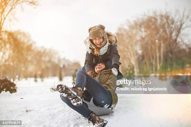 snow sliding with girlfrend - snow fun stock pictures, royalty-free photos & images