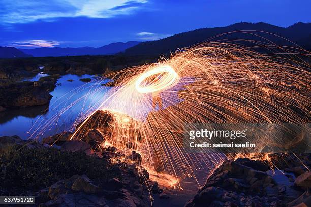 burning steel wool fireworks during blue hour, thailand - burning steel wool firework stock-fotos und bilder