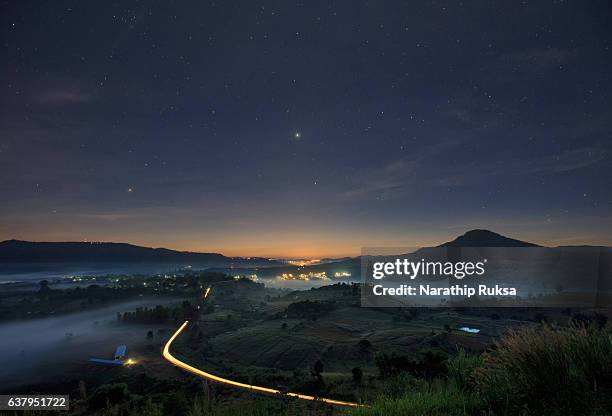 landscape misty view. fantastic dreamy sunrise on the mountains with a beautiful starry night. foggy clouds above the landscape. - twilight foto e immagini stock