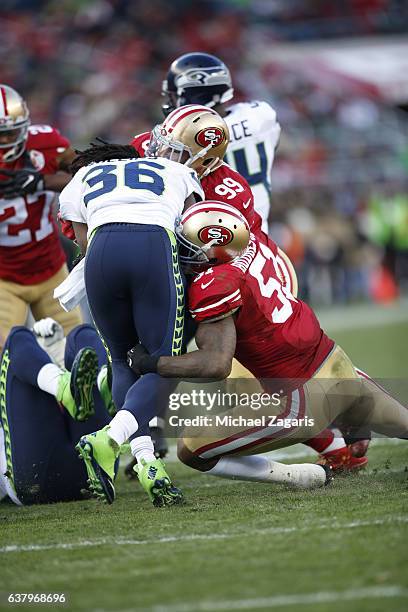 DeForest Buckner and Gerald Hodges of the San Francisco 49ers tackle Alex Collins of the Seattle Seahawks during the game at Levi Stadium on January...