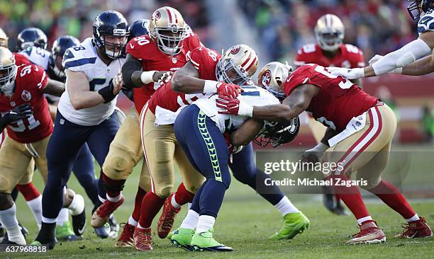 DeForest Buckner and Ahmad Brooks of the San Francisco 49ers tackle Thomas Rawls of the Seattle Seahawks during the game at Levi Stadium on January...