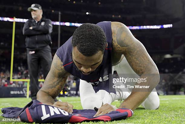 Eddie Pleasant of the Houston Texans autographs his jersey after the game against the Oakland Raiders at NRG Stadium on January 7, 2017 in Houston,...