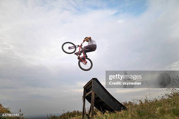 geschickte mountainbike-radfahrer mit geraden luftsprung. - rampe stock-fotos und bilder