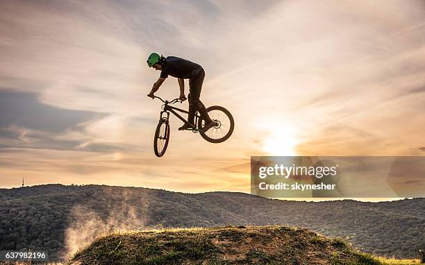 geschickter mann auf dem mountainbike üben 360 xup bei sonnenuntergang. - bmx stock-fotos und bilder