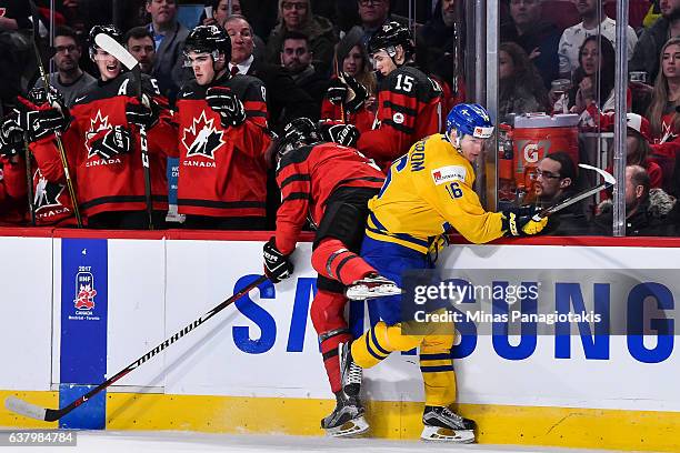 Carl Grundstrom of Team Sweden checks Noah Juulsen of Team Canada into the boards during the 2017 IIHF World Junior Championship semifinal game at...
