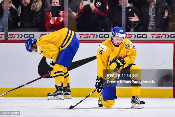 Oliver Kylington and teammate Jens Looke of Team Sweden react after losing to Team Canada during the 2017 IIHF World Junior Championship semifinal...