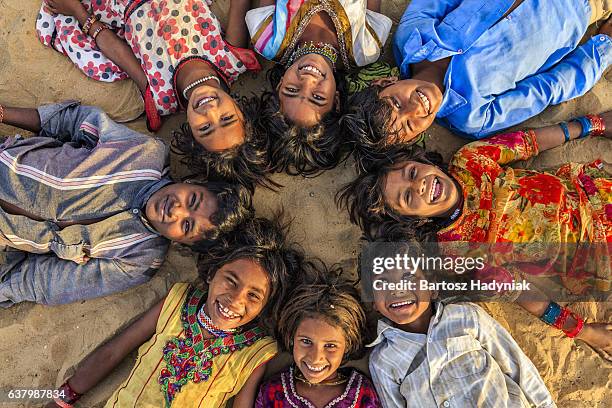 eine gruppe von glücklich gypsy indischen kinder liegen im kreis, indien - rajasthani youth stock-fotos und bilder