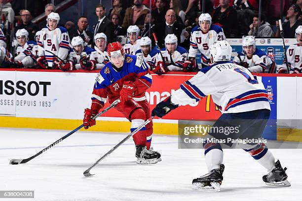 Alexander Polunin of Team Russia prepares to play the puck past Casey Fitzgerald of Team United States during the 2017 IIHF World Junior Championship...