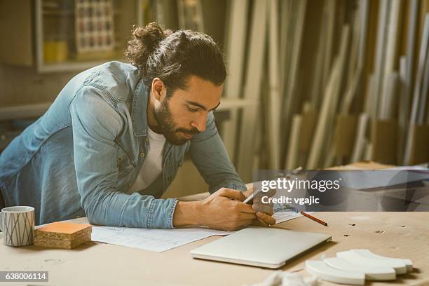 male carpenter working in his workshop - man bun stock pictures, royalty-free photos & images