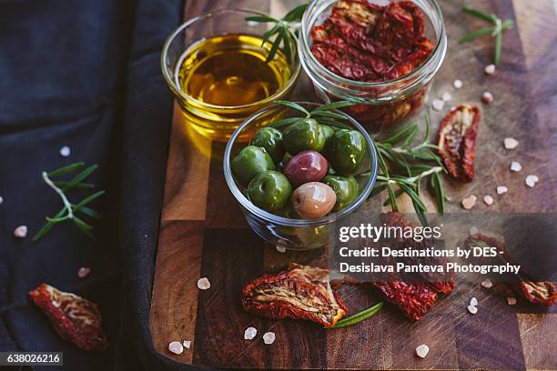 green olives, extra virgin olive oil and dry tomatoes pieces - sonnengetrocknete tomate stock-fotos und bilder