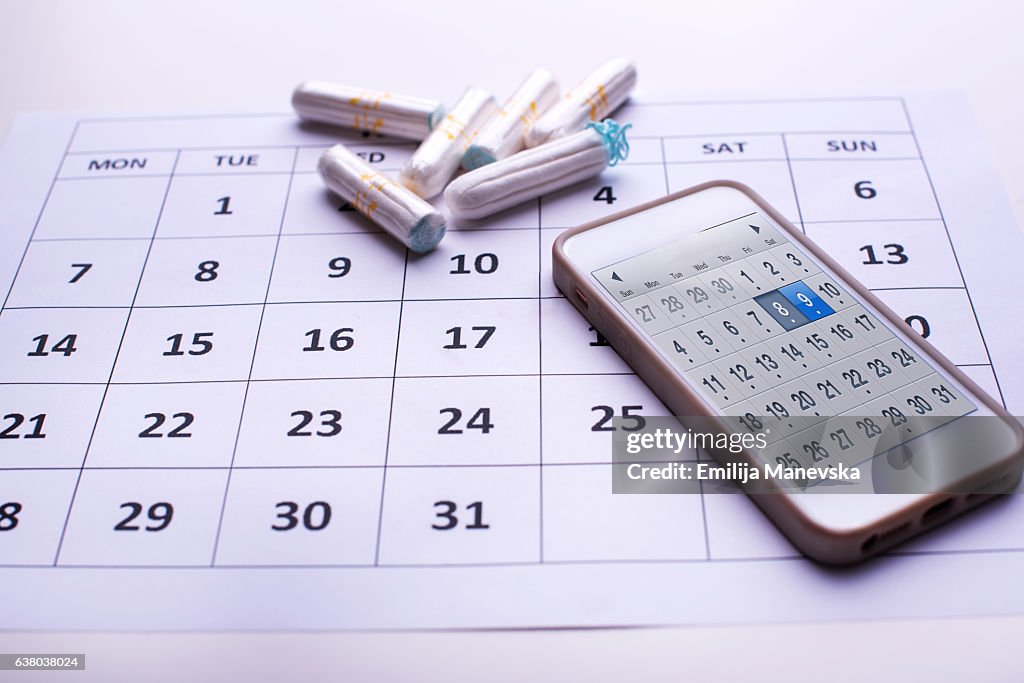 Clean white tampons, mobile phone and Calendar