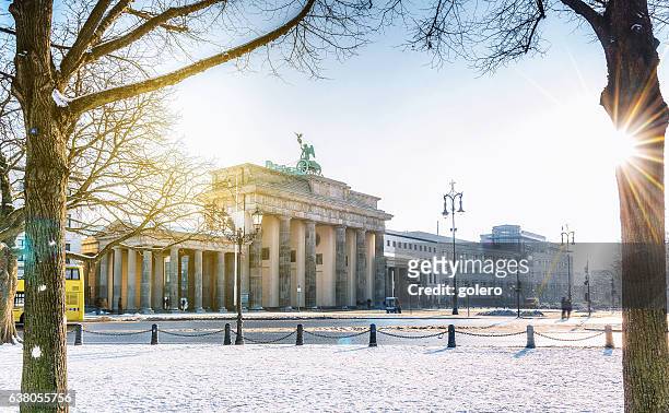 blick auf das berliner brandenburger tor mit schnee in der morgensonne - berlin stock-fotos und bilder