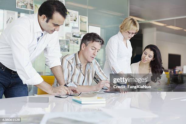 compañeros de trabajo de negocios que colaboran en la mesa de conferencias en el estudio de planificación - propiedad intelectual fotografías e imágenes de stock