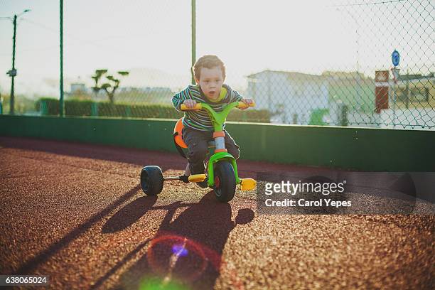 boy playing in trycicle outdoors - triciclo fotografías e imágenes de stock