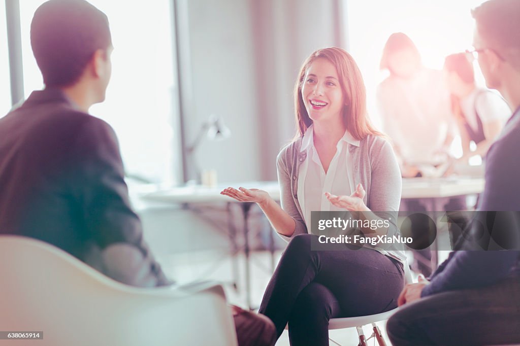 Office coworkers talking during meeting together in design studio