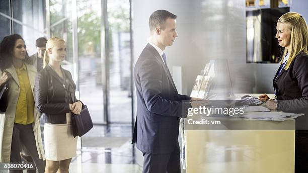 businessman talking to bank teller at the counter - lobby screen stock pictures, royalty-free photos & images