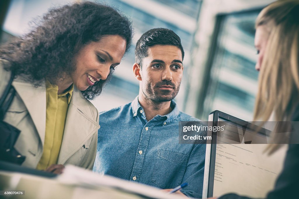 Couple talking to insurance agent at the counter