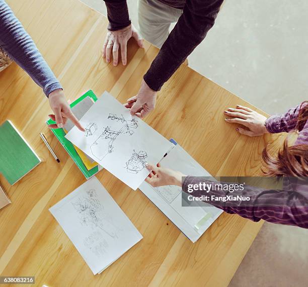 overhead view of designers collaborating at table in studio - intellectueel eigendom stockfoto's en -beelden