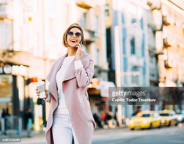 schöne elegante frau am telefon sprechen - pink coat stock-fotos und bilder