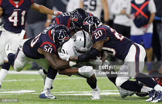 Jalen Richard of the Oakland Raiders is tackled by Akeem Dent of the Houston Texans, Brennan Scarlett and Don Jones in their AFC Wild Card game at...
