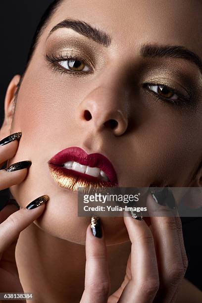 sensual woman gripping cheeks with fingers - gold eyeshadow imagens e fotografias de stock