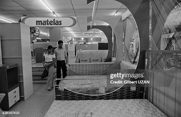 Un couple au rayon literie d'un supermarché Conforama en banlieue parisienne, en France, en mai 1976.