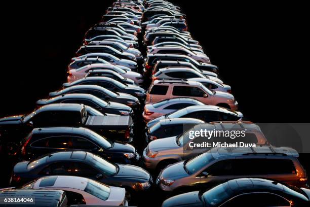 cars parked at night in a row in a parking lot. - cars parked in a row stock pictures, royalty-free photos & images