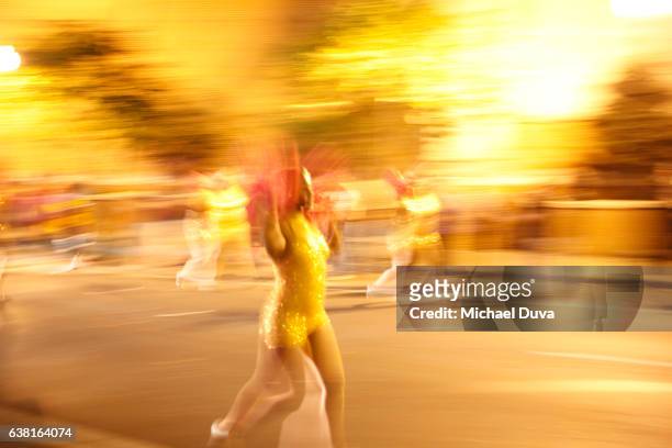 woman dancing and marching in a parade moving across frame in a blur at a parade in new orleans. - new orleans parade stock pictures, royalty-free photos & images