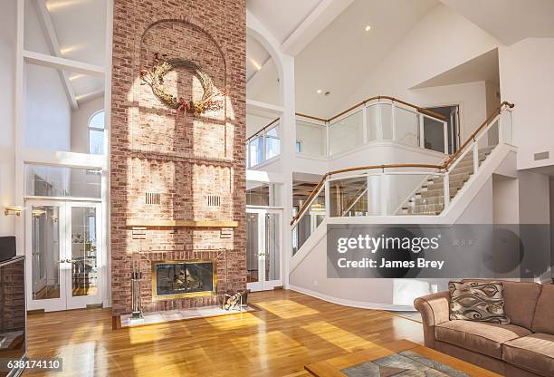 amazing home interior with brick fireplace and spectacular glass staircase. - cathedral ceiling stock pictures, royalty-free photos & images