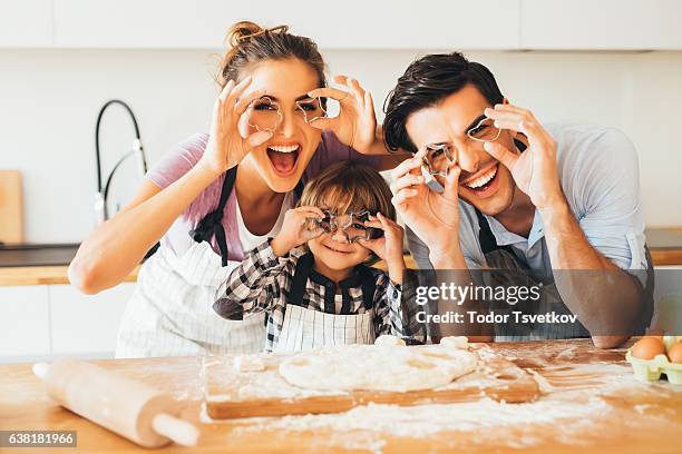 familie mit spaß in der küche - mutter kind lachen zuhause stock-fotos und bilder