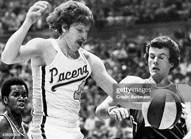Johnny Neumann of the Indiana Pacers leaps to knock the ball away from a startled Dave Robisch of the Denver Nuggets. At left is Ralph Simpson of...