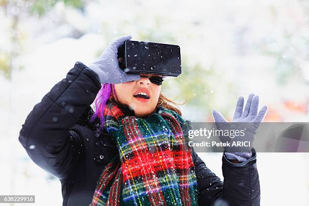 young woman using a virtual reality glasses on winter - hands free apparaat stockfoto's en -beelden