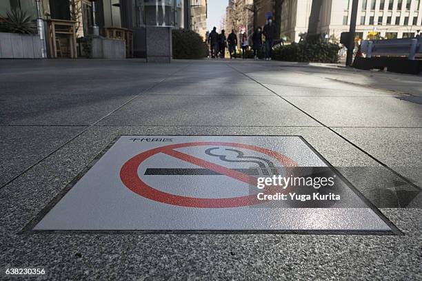 no smoking sign on the sidewalk in marunouchi, chiyoda-ward - nederzettingen stockfoto's en -beelden