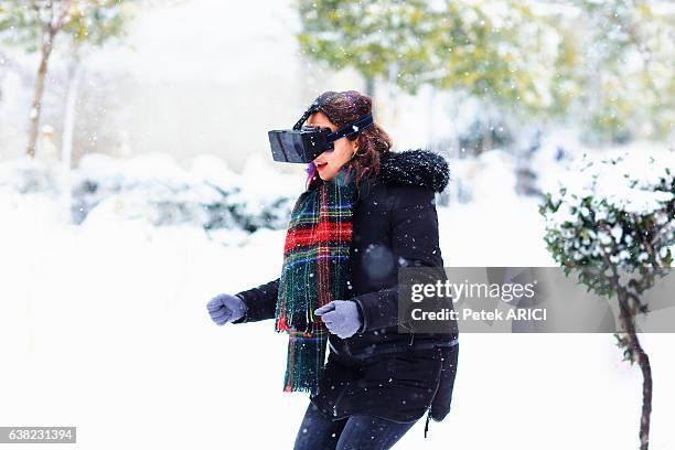 woman wearing vr in winter landscape pretending to skiing - hands free apparaat stockfoto's en -beelden