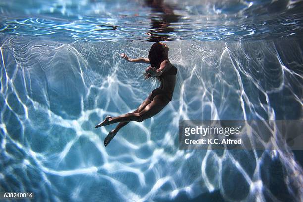 portrait of a female model underwater in a swimming pool with a in san diego, california. - legs in water stock pictures, royalty-free photos & images