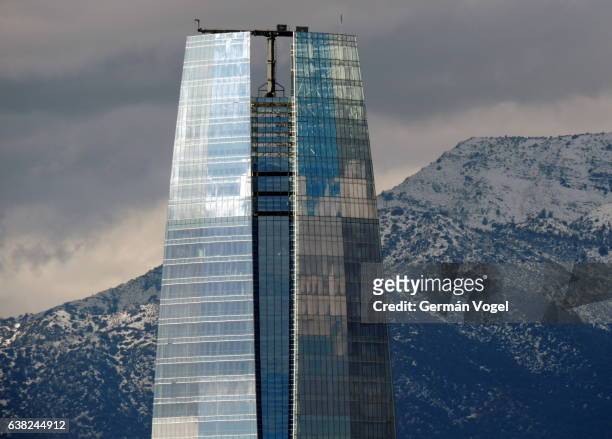 building and mountain competition - tallest building in south america, above snowed andes mountain peaks - santiago, chile - costanera center stock pictures, royalty-free photos & images